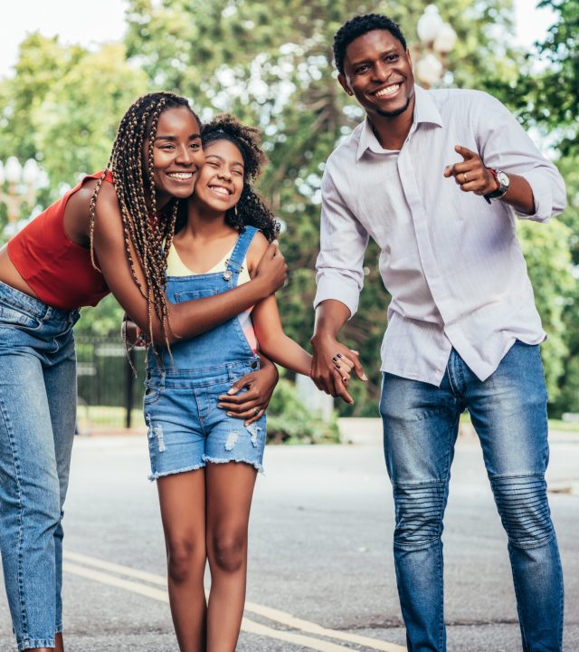 African American family enjoying a day together while walking outdoors on the street. Urban concept.